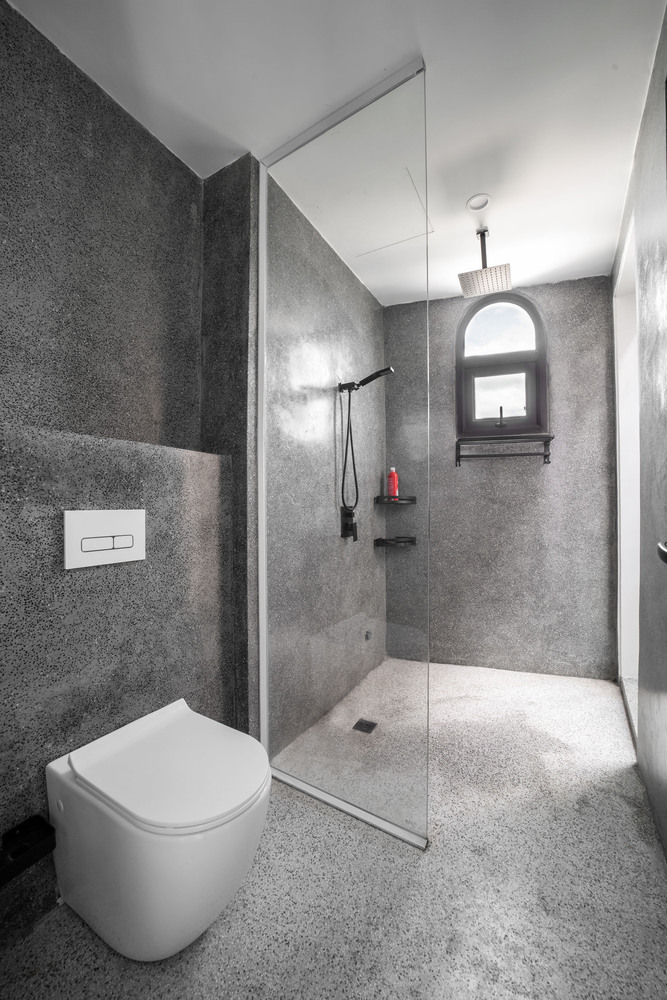 Phòng tắm tông màu xám bê tông trung tính, sạch sẽ.