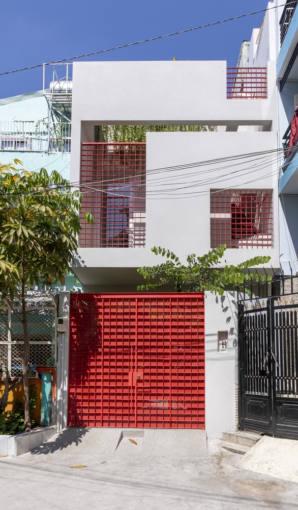 Nhà phố hút mọi ánh nhìn bởi cửa cổng màu đỏ cam nổi bật và thiết kế mặt tiền vừa thông thoáng, vừa đảm bảo sự kín đáo nhất định.