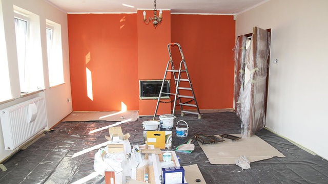 hình ảnh một căn phòng đang trong quá trình cải tạo, bức tường màu đỏ cam