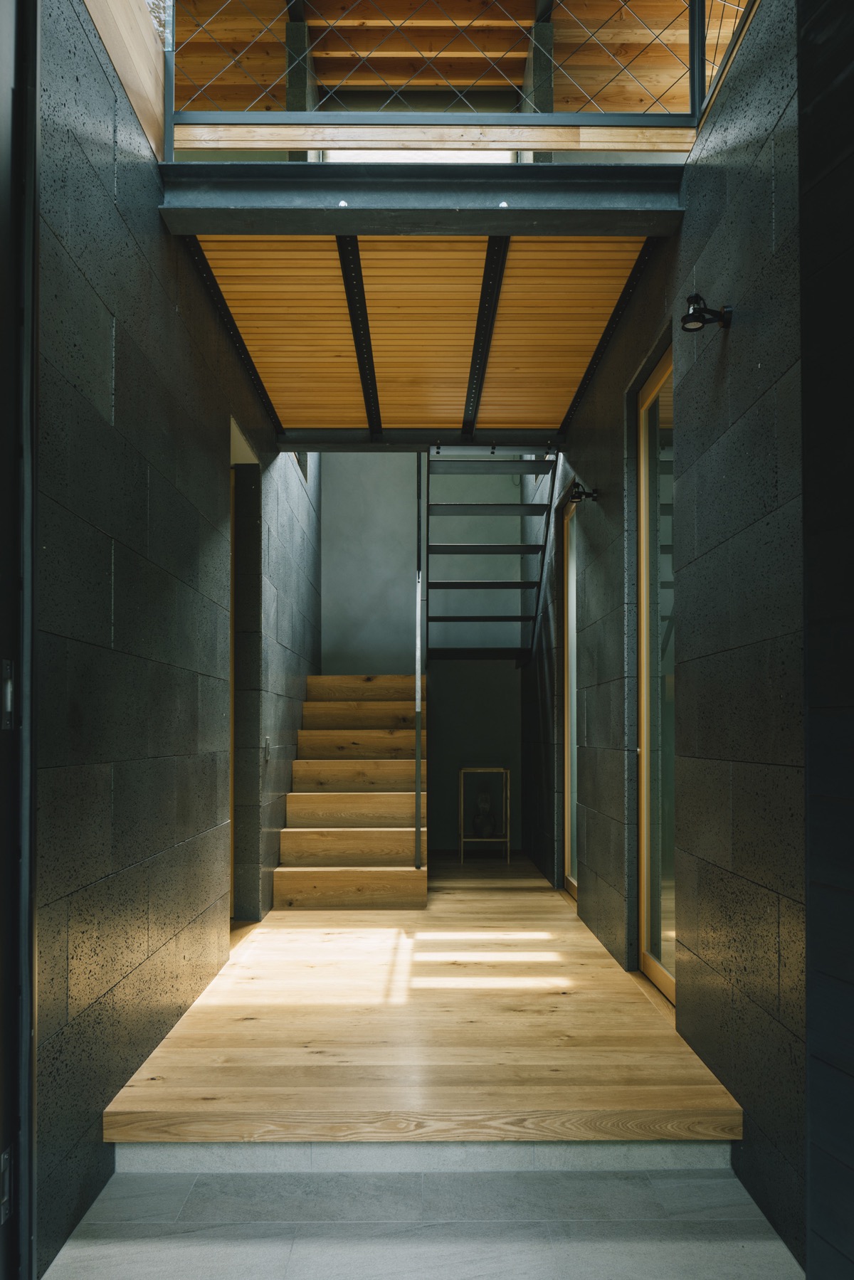 Thiết kế cầu thang bằng gỗ và kim loại phong cách công nghiệp. Các bậc thang bằng kim loại mở cho phép ánh sáng xuyên qua.