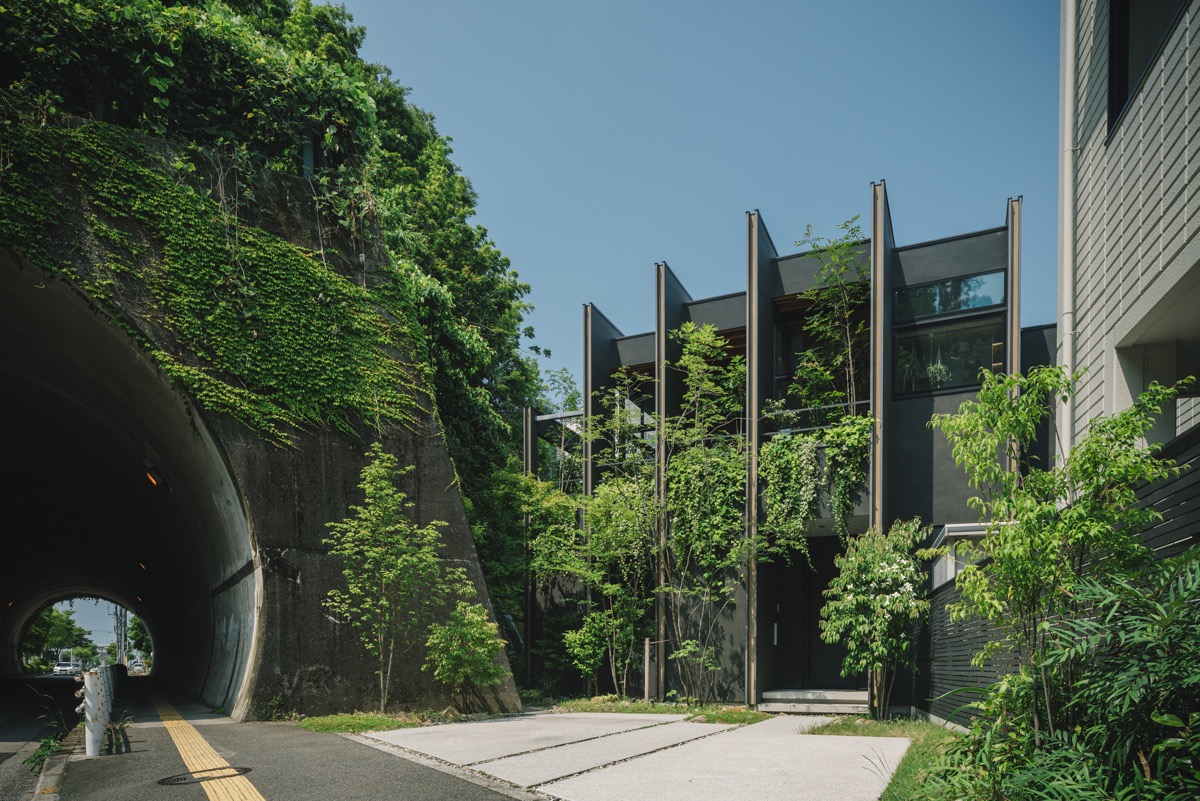 toàn cảnh mặt tiền ngôi nhà ở Nhật với đường hầm bao bọc bởi cây xanh.