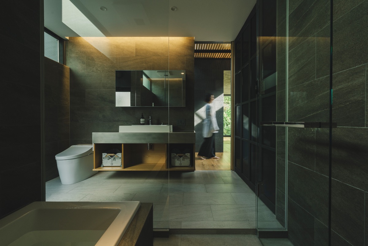 Phòng tắm nằm bên cạnh các phòng ngủ. Căn phòng tận dụng ánh sáng tự nhiên nhờ các khe hở tinh tế trên tường, trần.