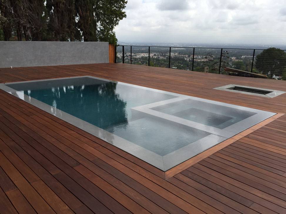 Sàn bể bơi tràn trông thật hút mắt với sự kết hợp giữa chất liệu gỗ - bê tông.