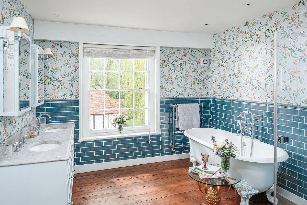 Phòng tắm đầy sức sống với giấy dán tường họa tiết, sàn gỗ và mặt bàn bằng đá cẩm thạch.