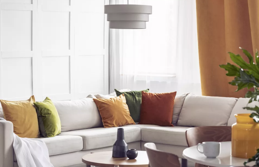 Bạn hãy đổi những chiếc gối tựa sofa mùa hè bằng gối nỉ, nhung màu vàng mù tạt, xanh lá cây và nâu đất để tạo bầu không khí ấm áp cho phòng khách màu trung tính chủ đạo.