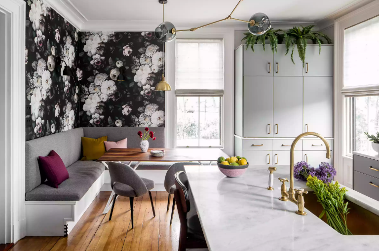 phòng bếp mùa thu với giấy dán tường bông hoa, ghế ngồi bọc nệm xám, gối tựa màu sắc