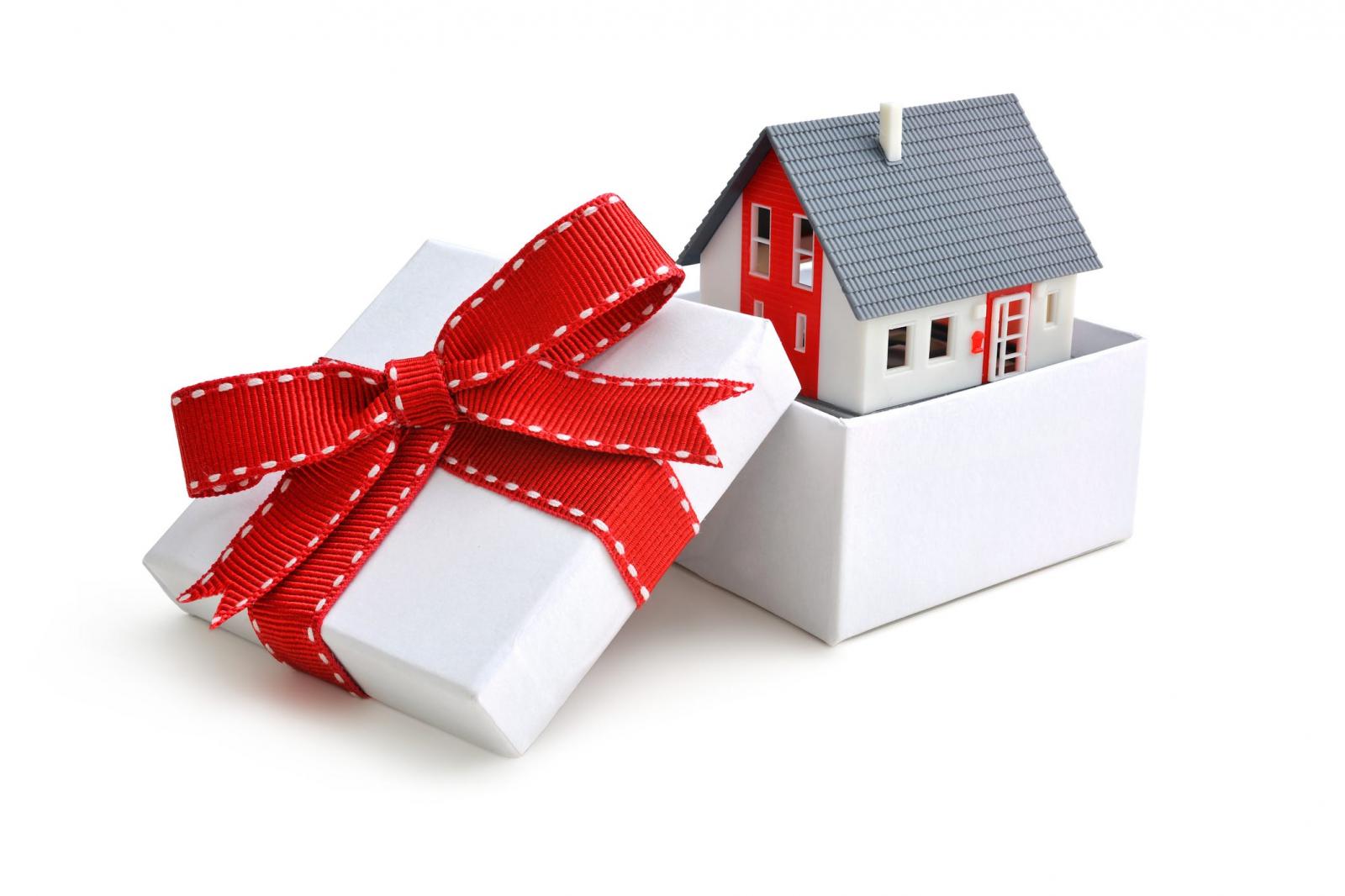 hình ảnh ngôi nhà nằm trong hộp quà màu trắng buộc ruy băng đỏ